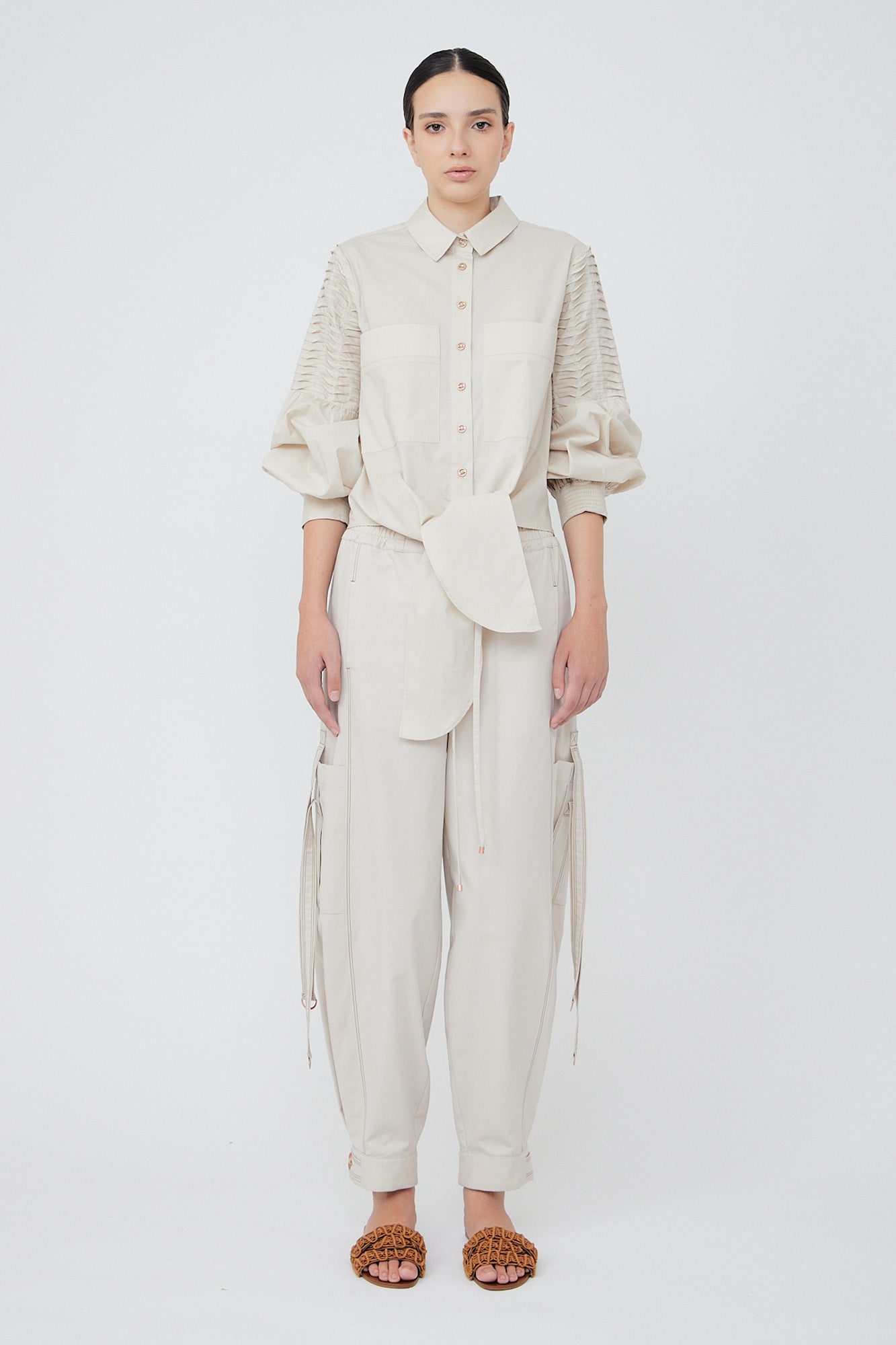 Paloma wide-leg pants made from 100% Pima cotton, featuring front and back patch pockets, side pockets with buckles, adjustable drawstring waistband, and double button cuffs.