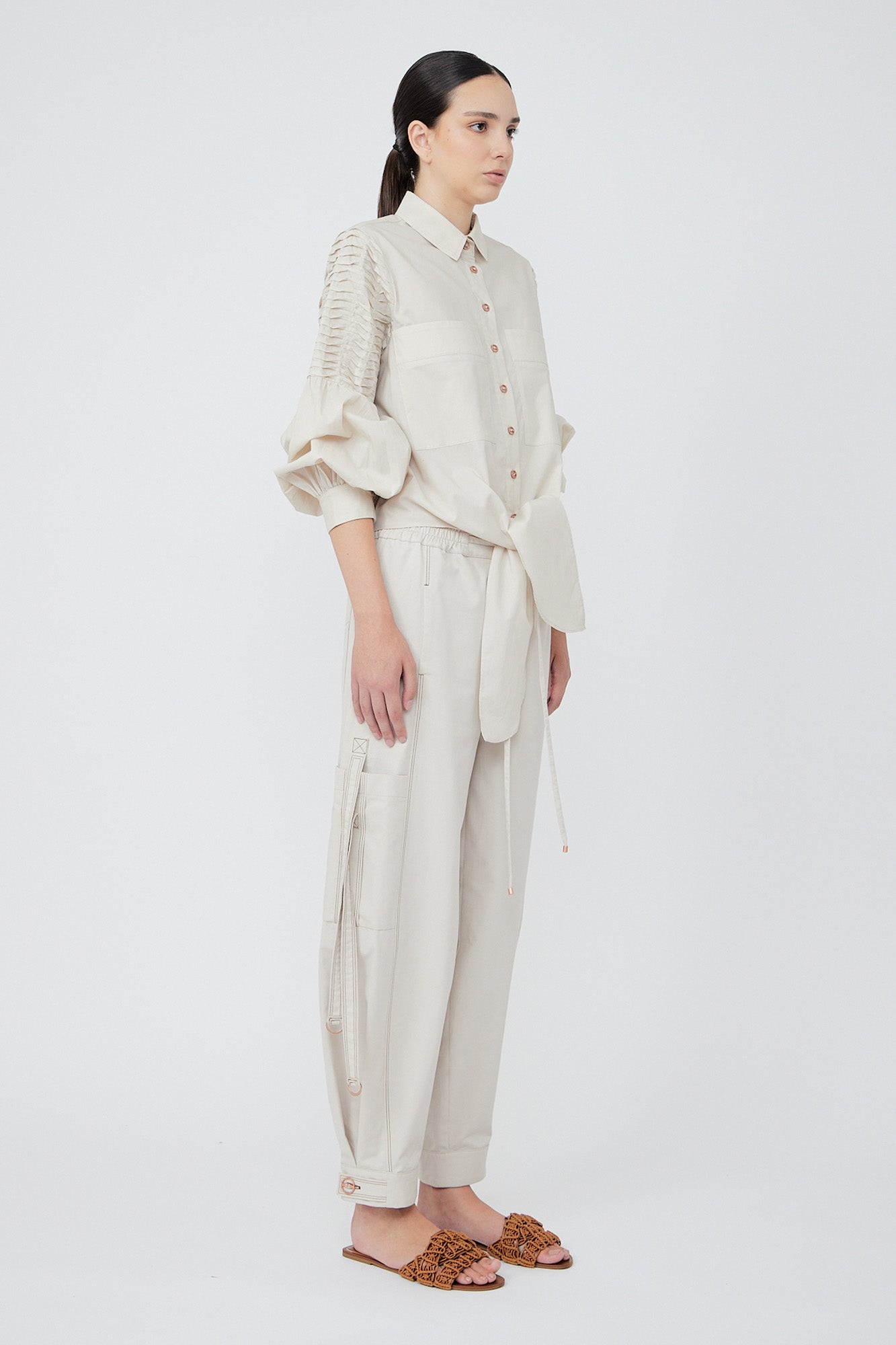 Paloma wide-leg pants made from 100% Pima cotton, featuring front and back patch pockets, side pockets with buckles, adjustable drawstring waistband, and double button cuffs.