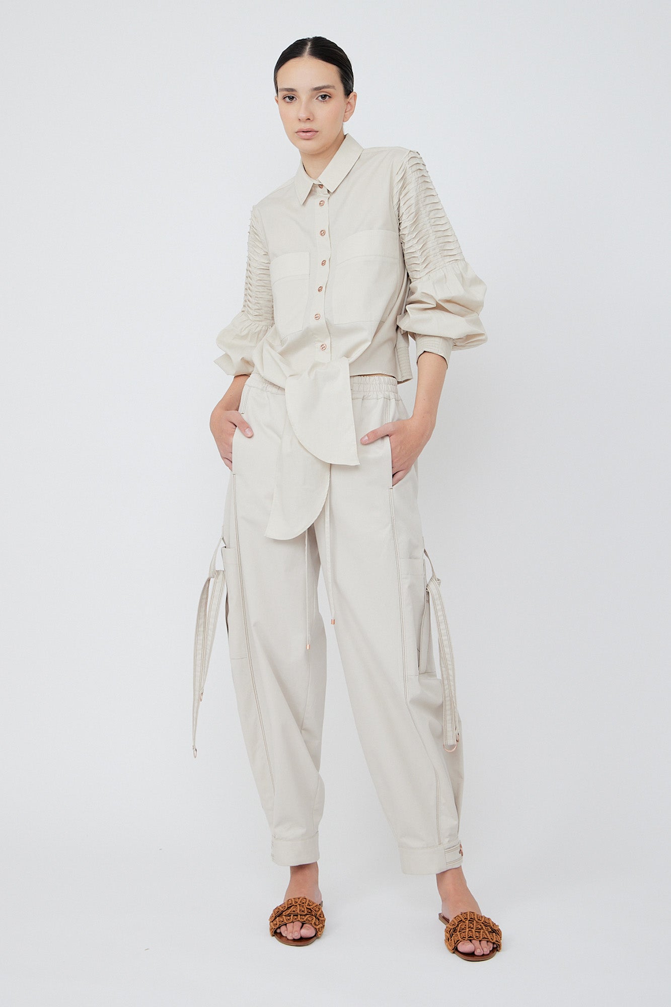 Paloma wide-leg pants made from 100% Pima cotton, featuring front and back patch pockets, side pockets with buckles, adjustable drawstring waistband, and double button cuffs.