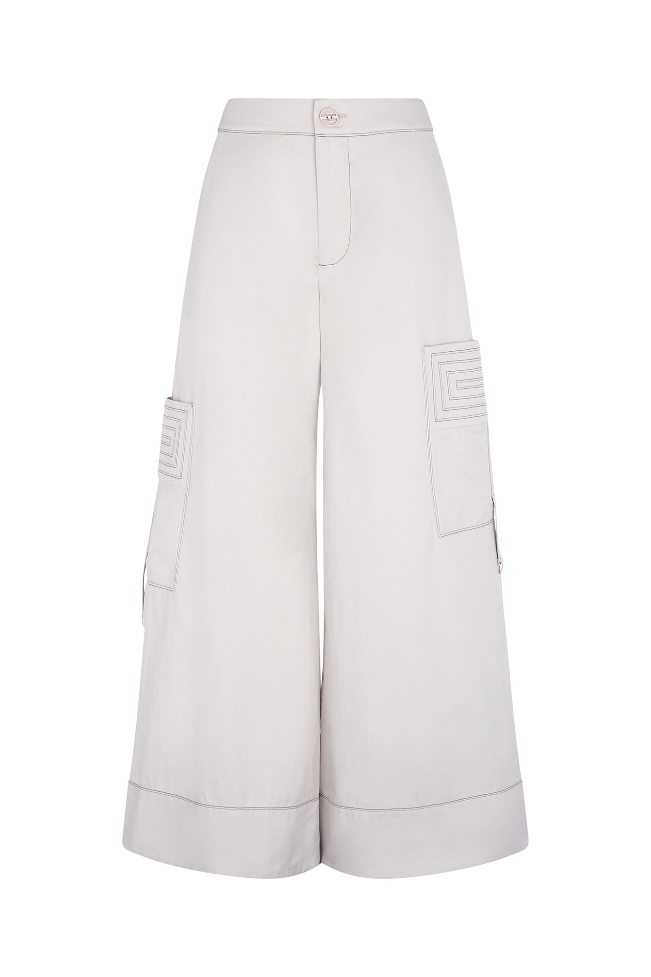 A woman modeling Belén palazzo pants in pristine white color, featuring side patch pockets with metal buckle straps.