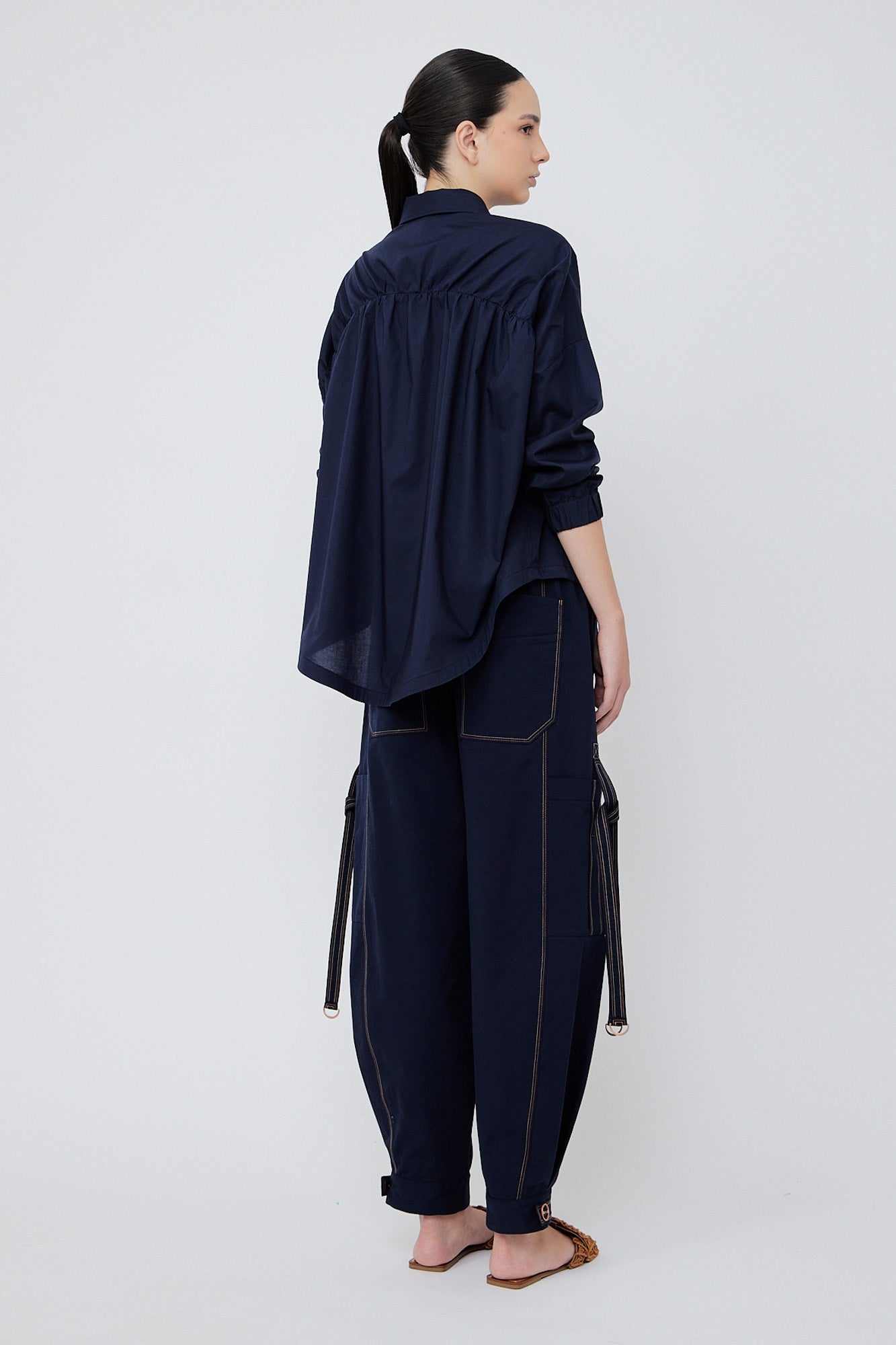 Paloma wide-leg pants made from 100% Pima cotton, featuring front and back patch pockets, side pockets with buckles, adjustable drawstring waistband, and double button cuffs.