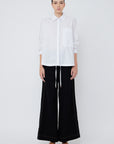 The Hebe Blouse in crisp white, featuring its clean lapel collar and innovative asymmetrical design.