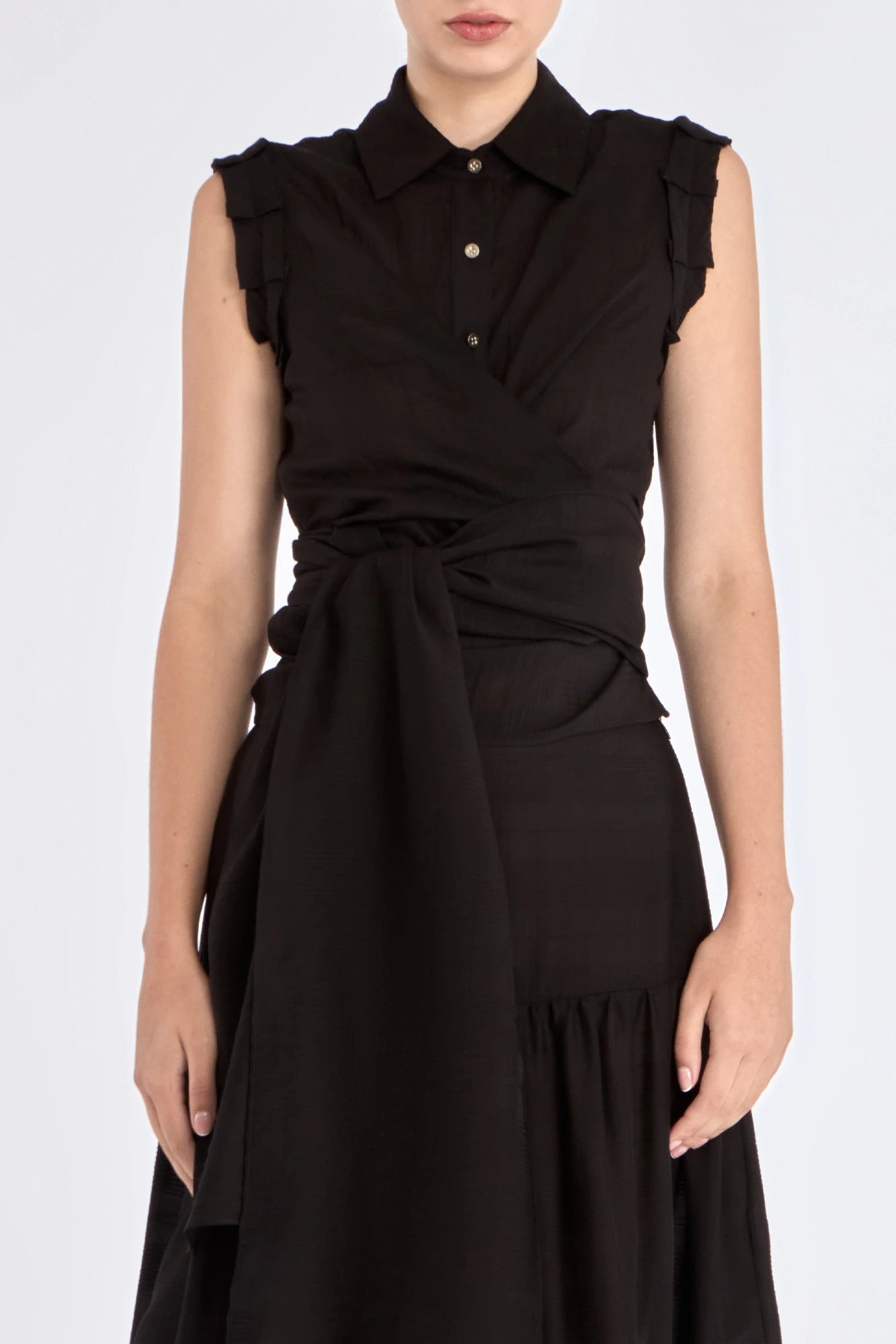 The Harlow Wrap Blouse in black, detailed with its polished metal buttons.