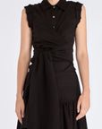 The Harlow Wrap Blouse in black, detailed with its polished metal buttons.