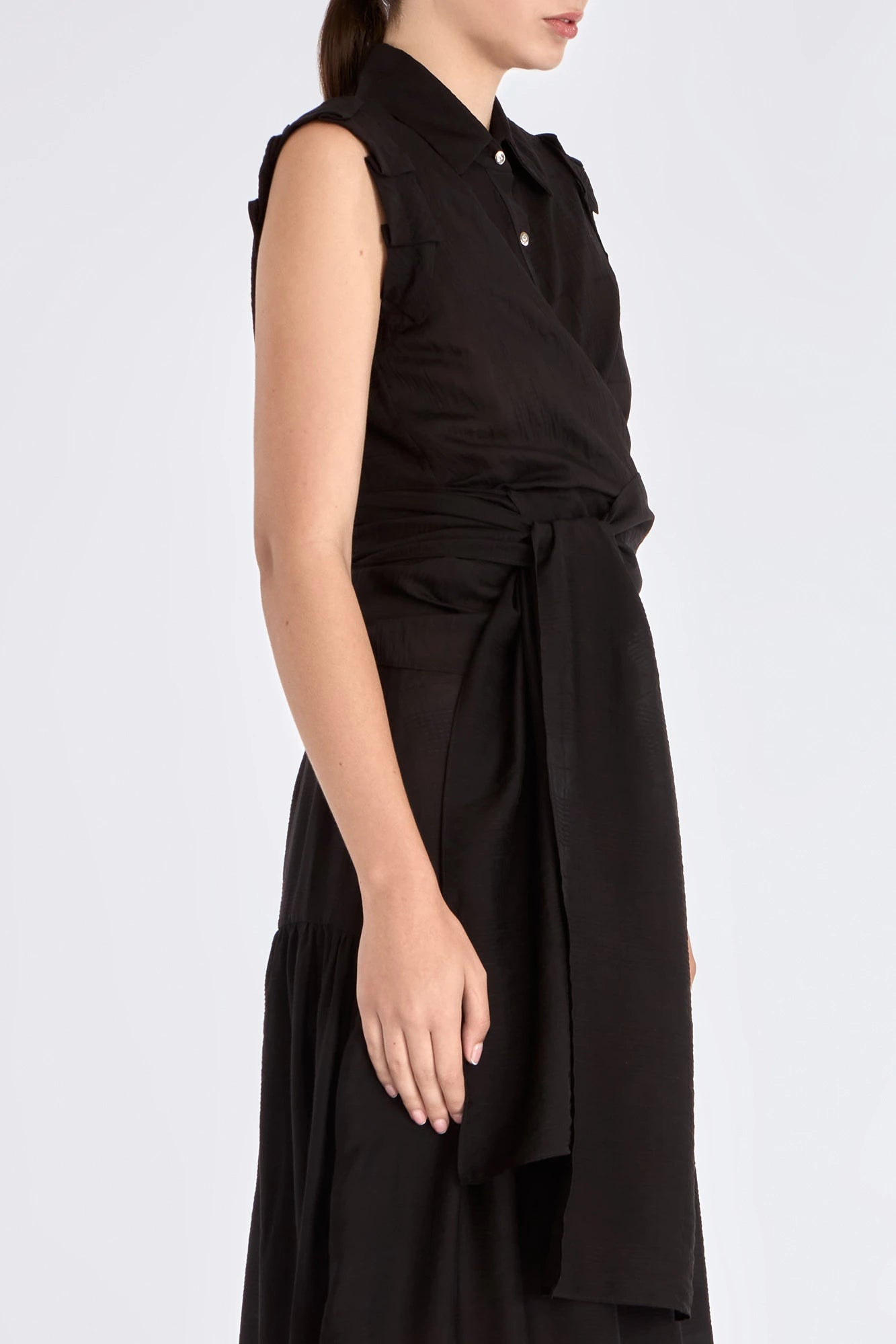 The Harlow Wrap Blouse in black, detailed with its polished metal buttons.