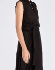 The Harlow Wrap Blouse in black, detailed with its polished metal buttons.