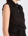 The Harlow Wrap Blouse in black, detailed with its polished metal buttons.