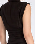 The Harlow Wrap Blouse in black, detailed with its polished metal buttons.