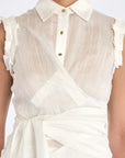 Close-up detail of the signature metal button on the Harlow Blouse.