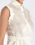 Close-up detail of the signature metal button on the Harlow Blouse.