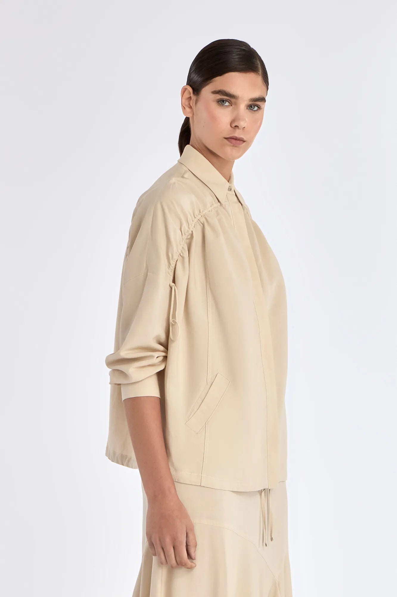 Side profile of the Ecru Ailani Jacket, showing the contrast between the tailored front and soft back.