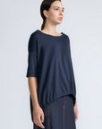 Amaya Top in Navy – Casual-chic cotton top with asymmetrical hem and hem pullers for versatile styling.