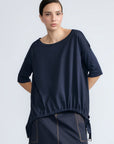 Amaya Top in Navy – Casual-chic cotton top with asymmetrical hem and hem pullers for versatile styling.