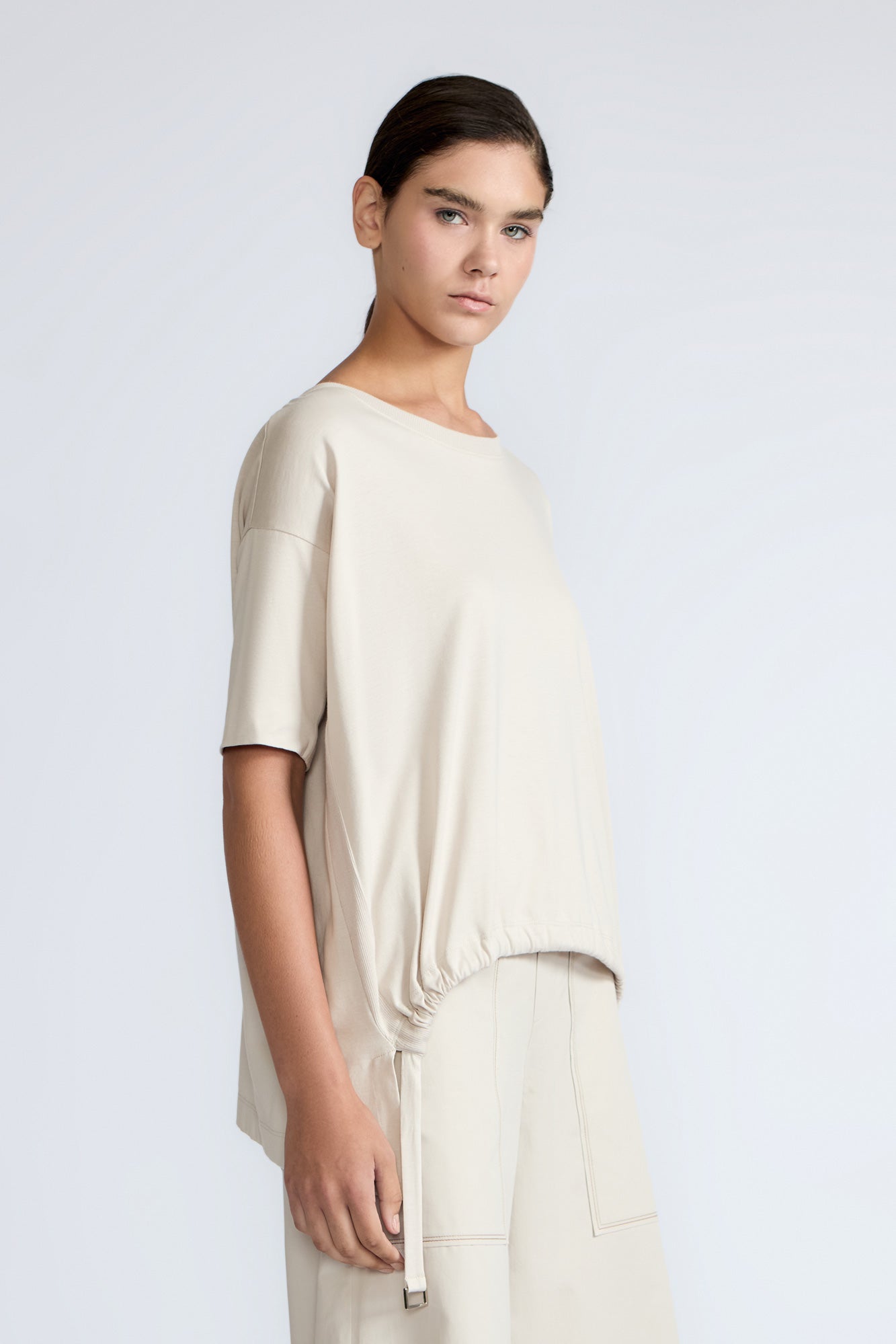Amaya Top in Prestine – Cotton short-sleeve top with asymmetric hemline and metal-tipped buckle drawstrings.