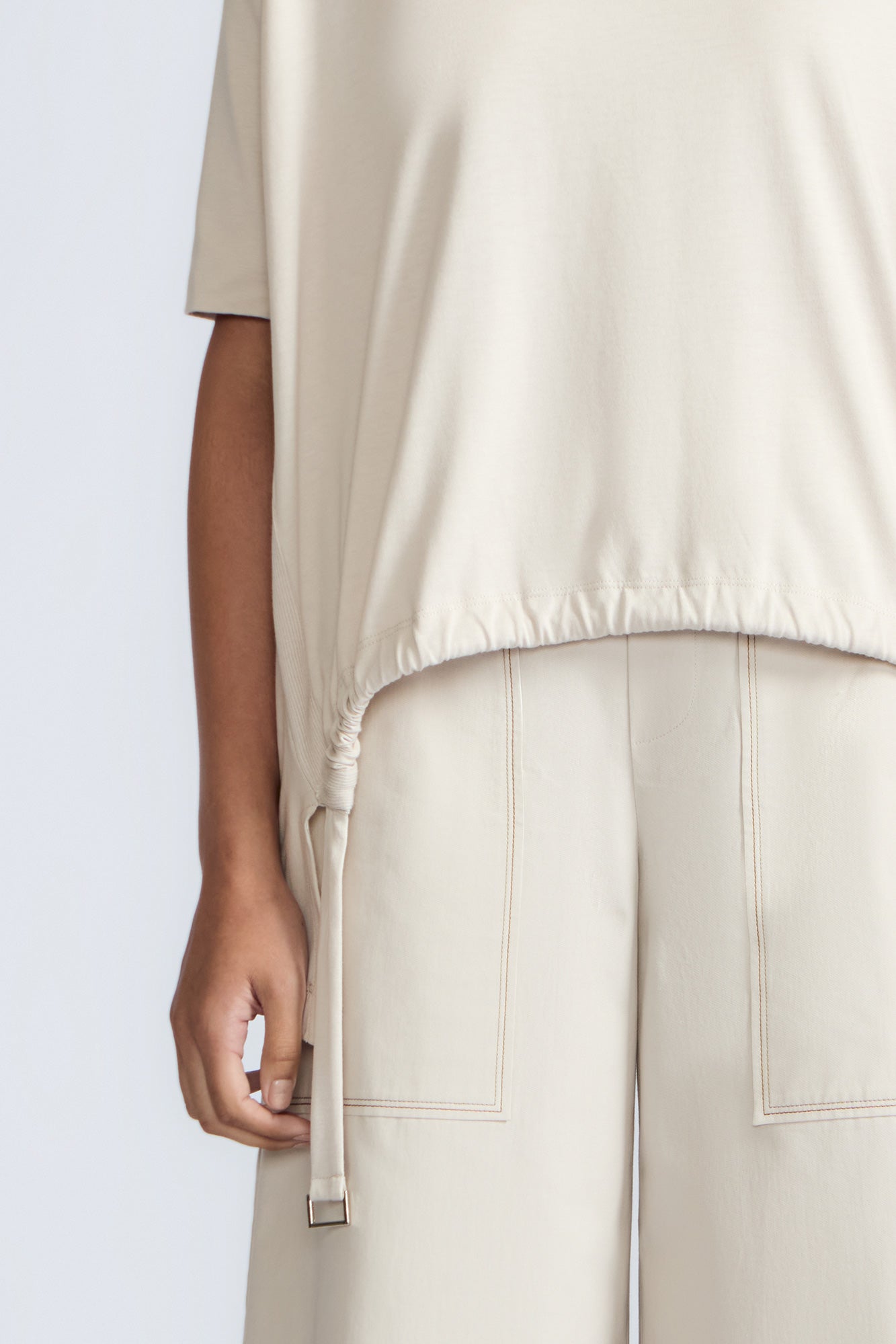 Amaya Top in Prestine – Cotton short-sleeve top with asymmetric hemline and metal-tipped buckle drawstrings.