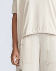 Amaya Top in Prestine – Cotton short-sleeve top with asymmetric hemline and metal-tipped buckle drawstrings.