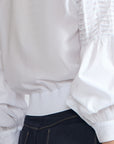 Ansley Blouse in White – Relaxed-fit cotton blouse with shirt collar, button front, and tied waist detail.