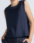 Avayah Top in Navy – 100% cotton sleeveless top with round neckline, shoulder button accents, and drawstring hem.