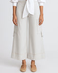 Person wearing light gray wide-leg pants with a white shirt on a white background
