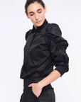 Side profile of the black Bimba Blouse, highlighting the dramatic, sculptural puff sleeves.