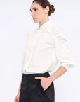 Side view of the white Bimba Blouse, showcasing the soft, romantic volume of its puff sleeves.