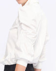 Detail shot of the sculptural puff sleeve and the premium cotton fabric of the white Bimba Blouse.