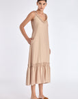 Side view of the Nude Blake Dress, showcasing the elegant movement of its gathered and pleated skirt.