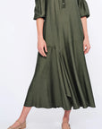 The Carlie Dress in a sophisticated Olive, featuring its soft puff sleeves and draped skirt.