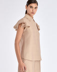 Side view of the Nude Clark Blouse, with a focus on the soft ruffle detail of the sleeve.
