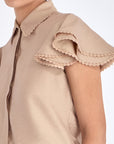 Detail shot of the delicate ruffle and tonal trim on the sleeve of the Nude Clark Blouse.