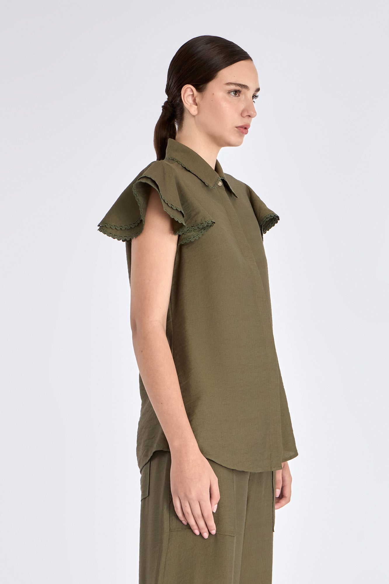 Side profile of the Olive Clark Blouse, highlighting the delicate ruffle detail on the short sleeve.