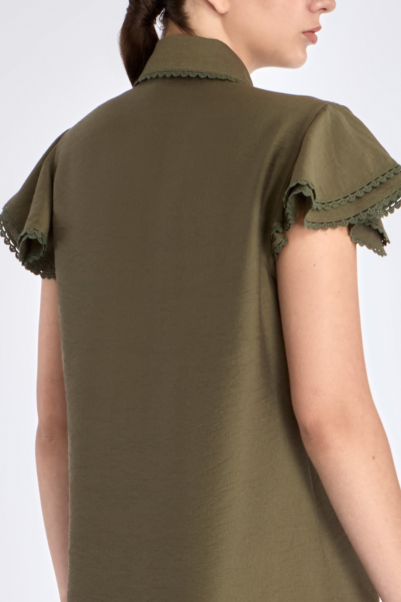 Clean back silhouette of the Clark Blouse, showing the elegant drape of the woven fabric.