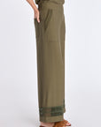 Side profile of the Olive Clark Ease Pant, highlighting the fluid drape of the proprietary knit.