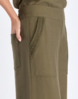 Detail of the tone-on-tone trim on the hem of the olive Clark Ease Pant, a soft knit trouser.