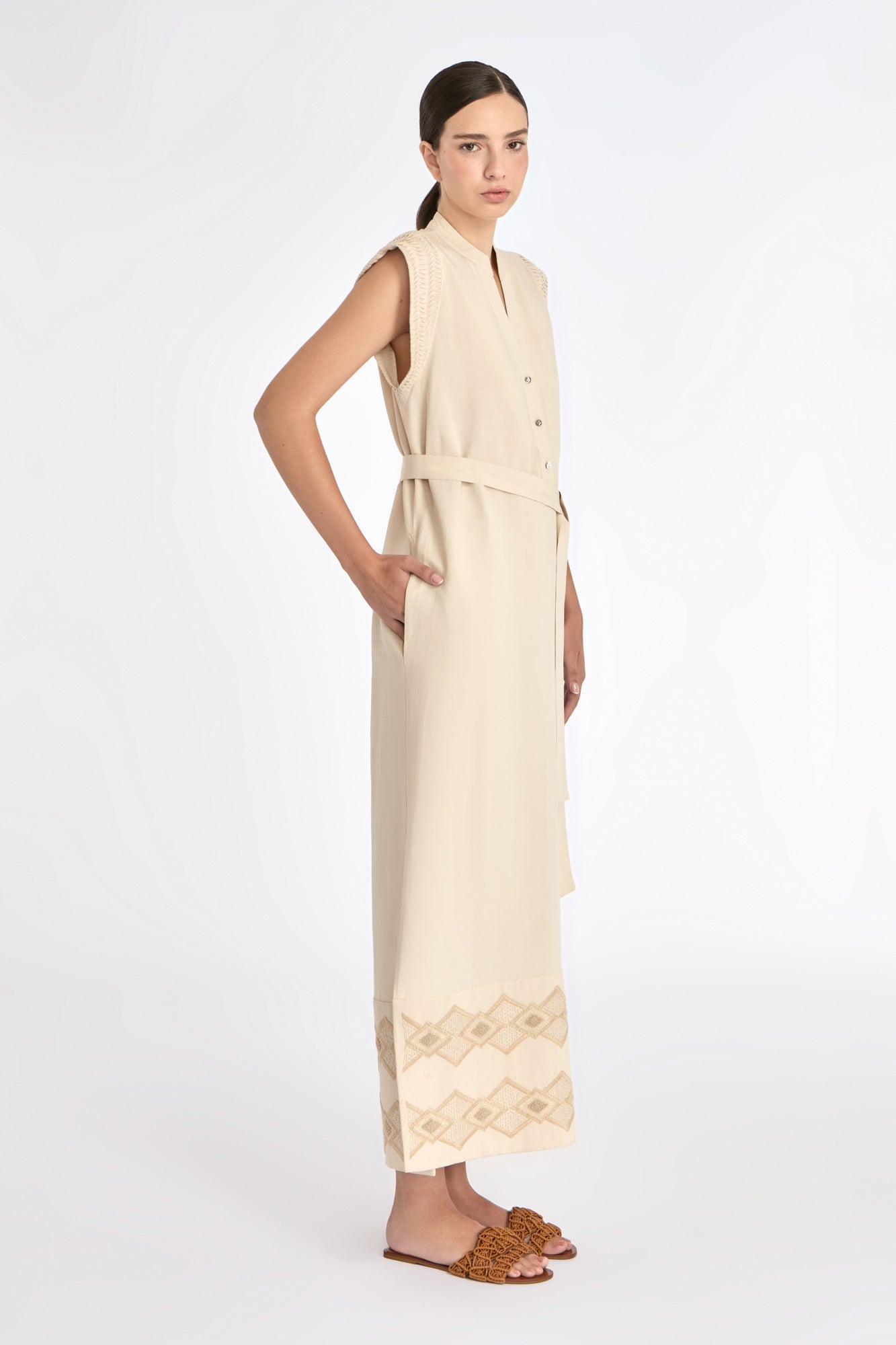 Denver Dress in Ecru – Sleeveless linen midi dress with embroidered hem by AMEDBAM, metal buttons, and fabric belt.