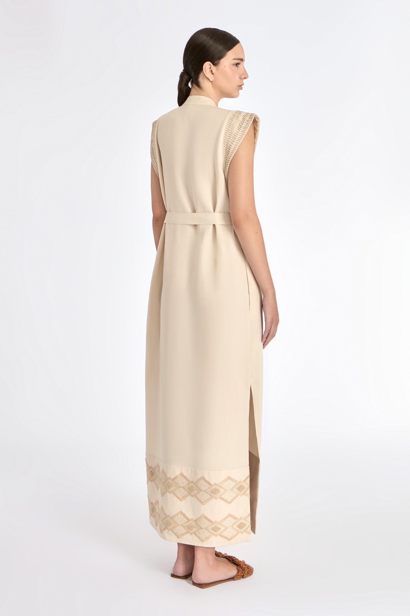 Denver Dress in Ecru – Sleeveless linen midi dress with embroidered hem by AMEDBAM, metal buttons, and fabric belt.