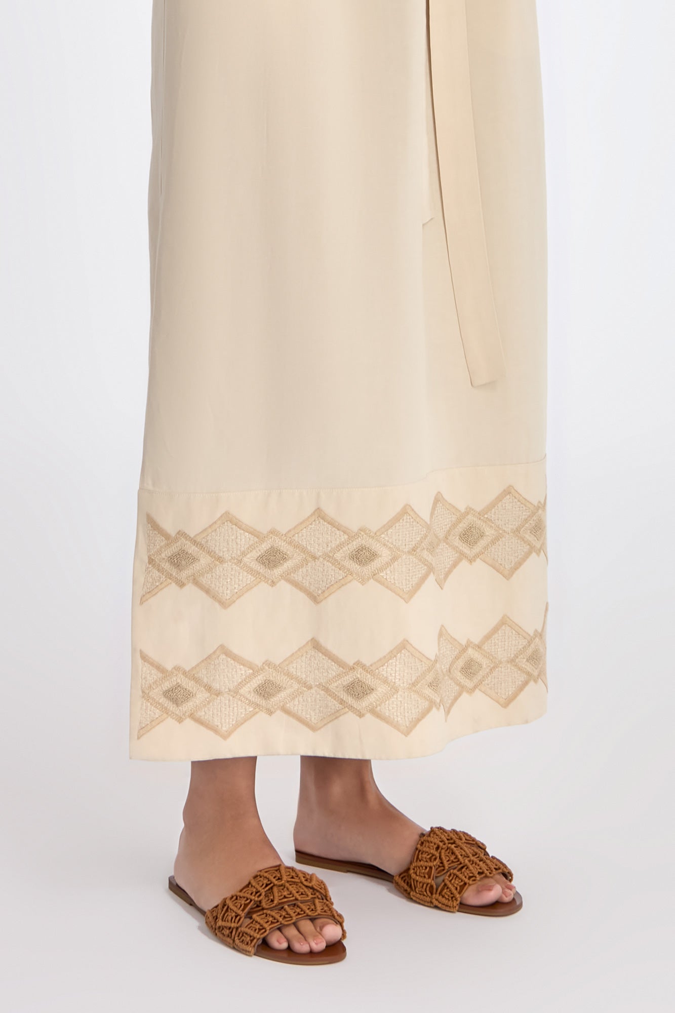 Denver Dress in Ecru – Sleeveless linen midi dress with embroidered hem by AMEDBAM, metal buttons, and fabric belt.