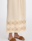 Denver Dress in Ecru – Sleeveless linen midi dress with embroidered hem by AMEDBAM, metal buttons, and fabric belt.