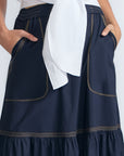 Eden Skirt in Navy – Cotton midi skirt with ruffled hem, front patch pockets, and elasticized back waistband.