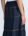 Eden Skirt in Navy – Cotton midi skirt with ruffled hem, front patch pockets, and elasticized back waistband.