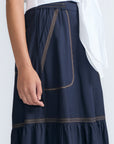 Eden Skirt in Navy – Cotton midi skirt with ruffled hem, front patch pockets, and elasticized back waistband.