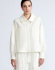 Gwen Jacket in Off White – Cropped cotton jacket with front pleats, shirt collar, and patch pockets.