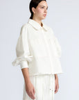 Gwen Jacket in Off White – Cropped cotton jacket with front pleats, shirt collar, and patch pockets.