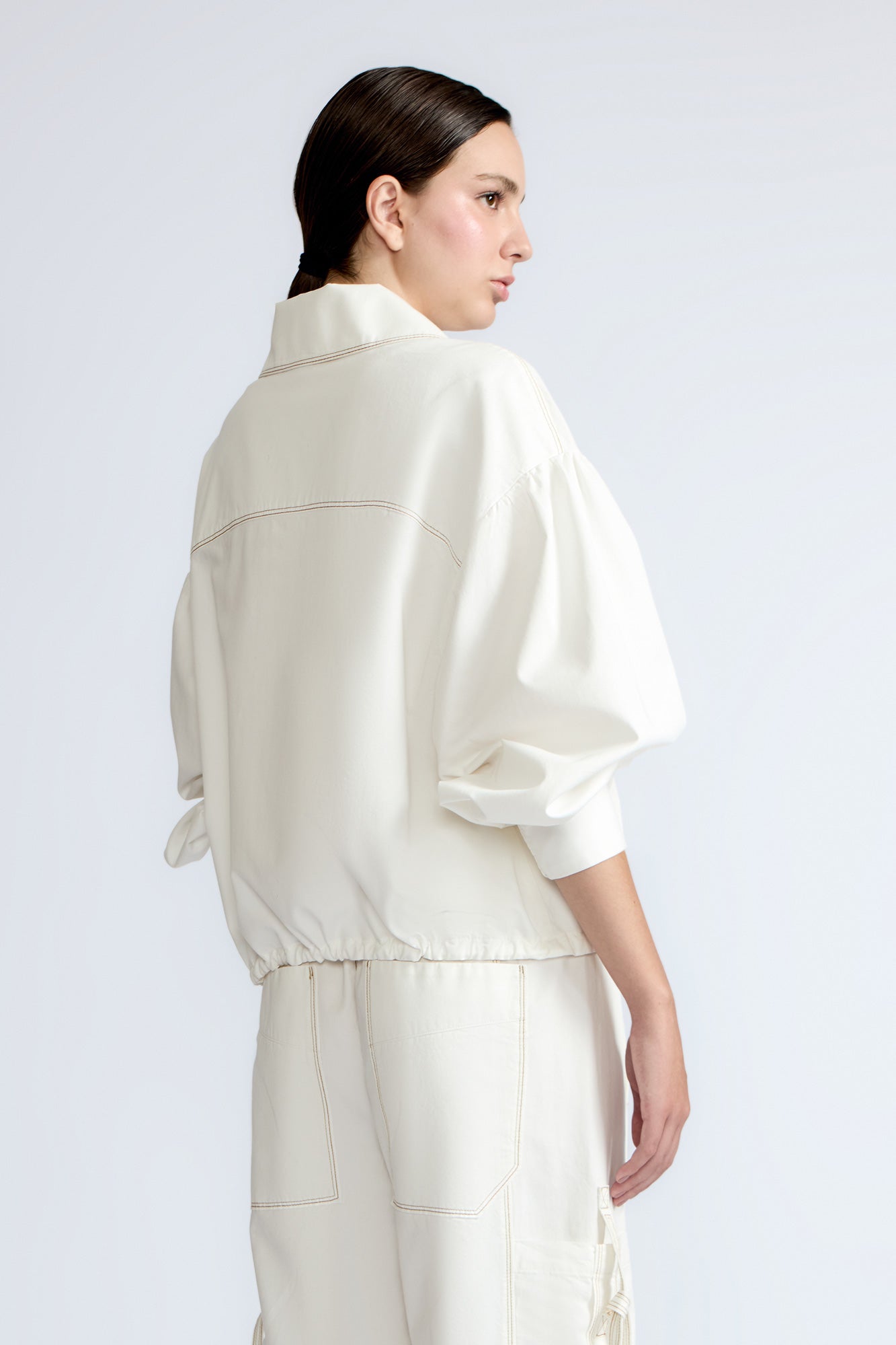 Gwen Jacket in Off White – Cropped cotton jacket with front pleats, shirt collar, and patch pockets.
