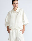 Gwen Jacket in Off White – Cropped cotton jacket with front pleats, shirt collar, and patch pockets.