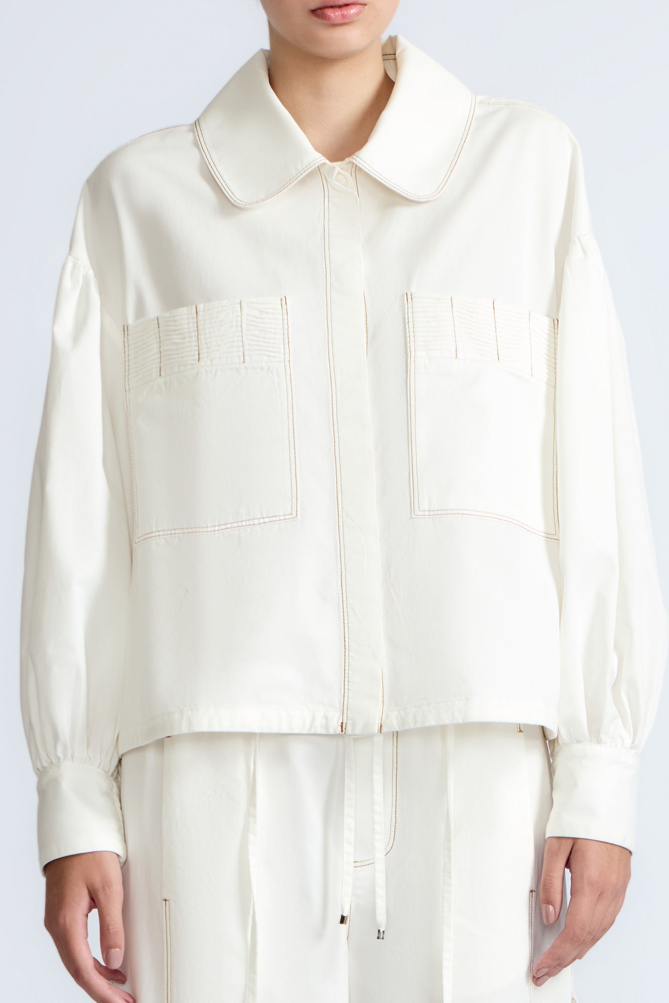 Gwen Jacket in Off White – Cropped cotton jacket with front pleats, shirt collar, and patch pockets.