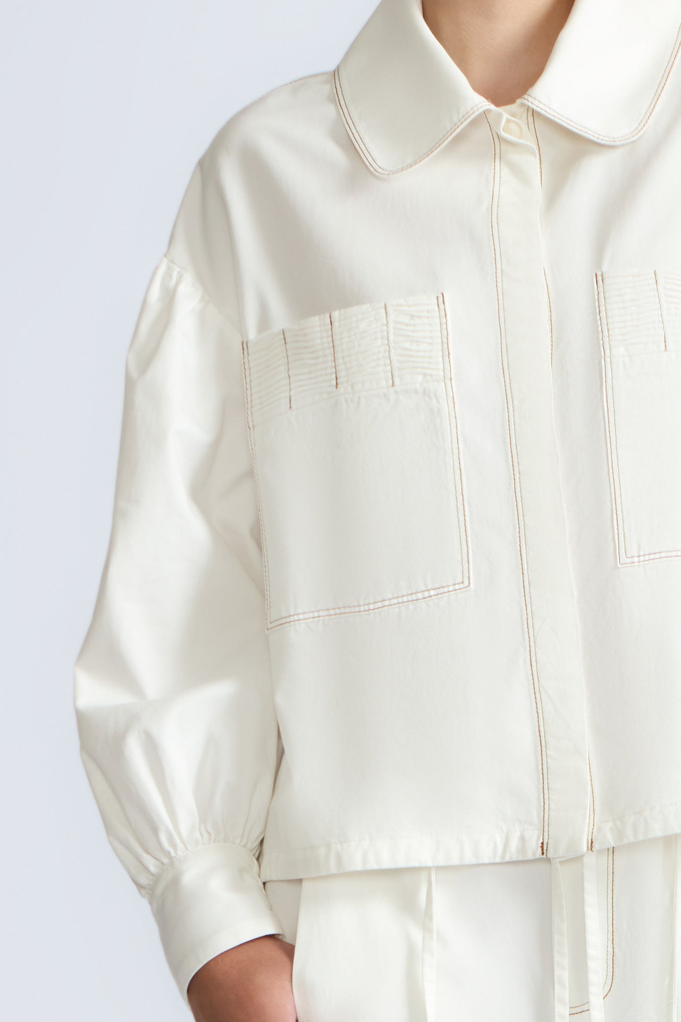 Gwen Jacket in Off White – Cropped cotton jacket with front pleats, shirt collar, and patch pockets.