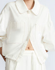 Gwen Jacket in Off White – Cropped cotton jacket with front pleats, shirt collar, and patch pockets.