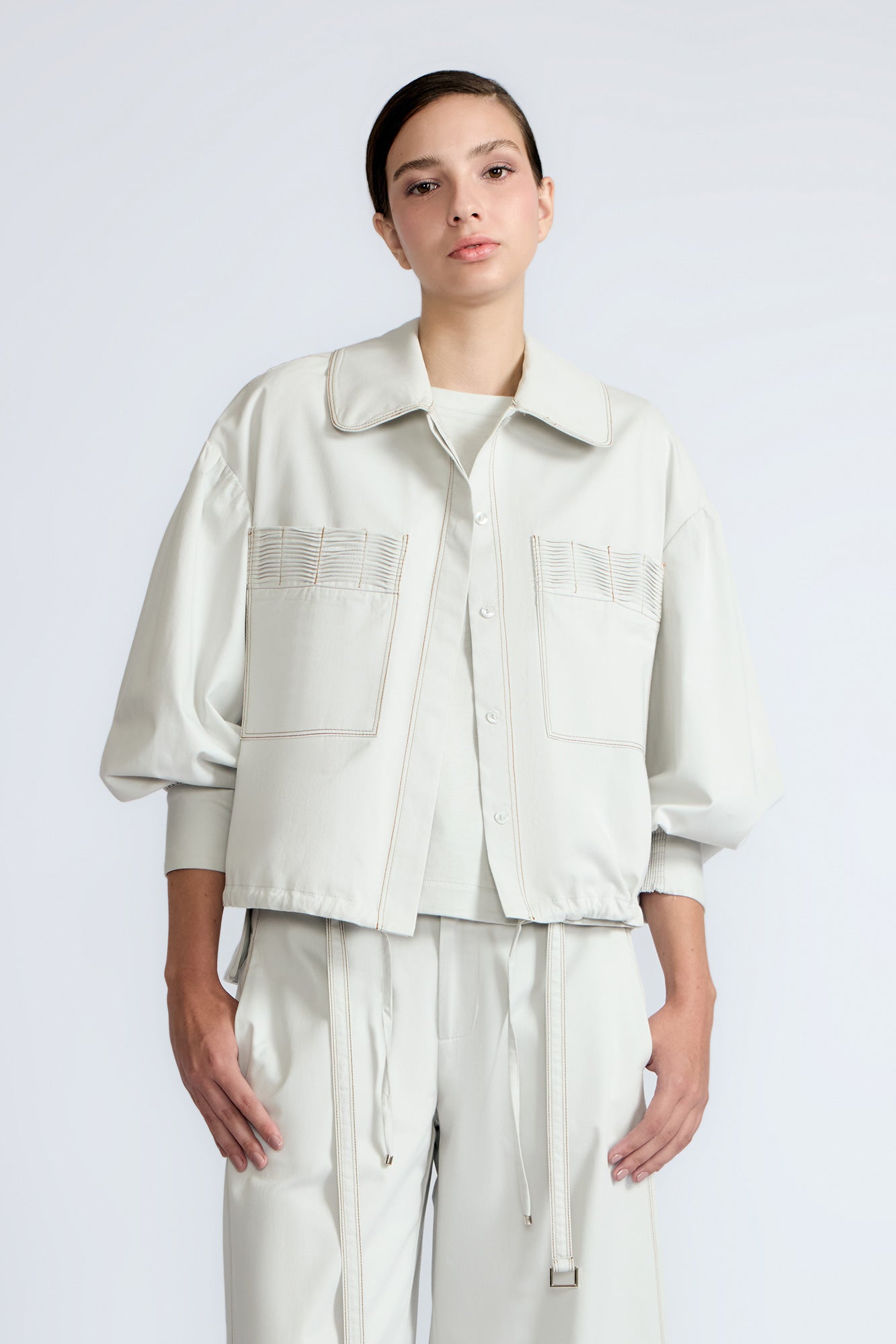 Gwen Jacket in Silver – Cropped cotton jacket with structured pleats, patch pockets, and a modern cut.