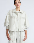 Gwen Jacket in Silver – Cropped cotton jacket with structured pleats, patch pockets, and a modern cut.
